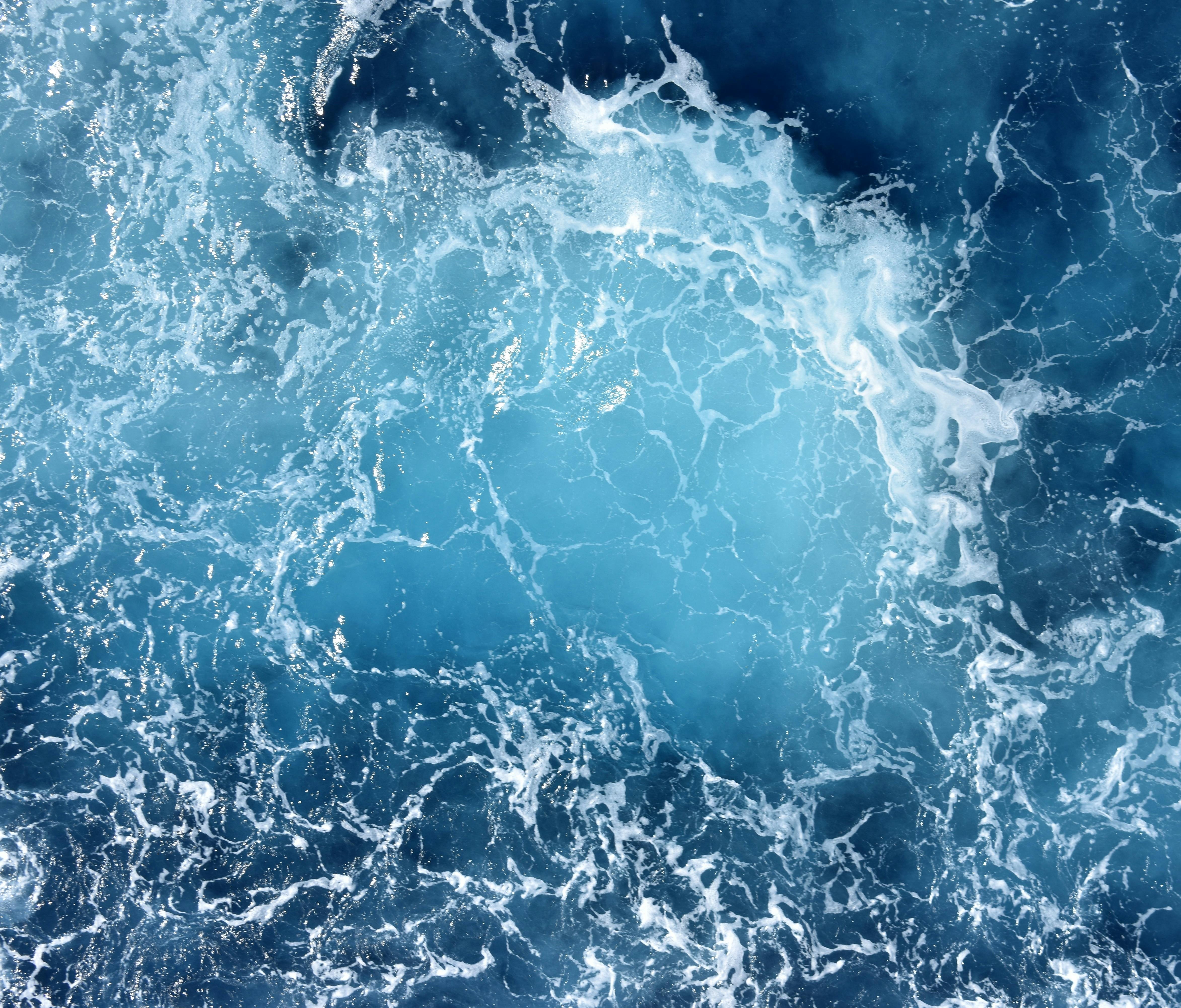 Bright deep blue ocean's water with crushing waves.